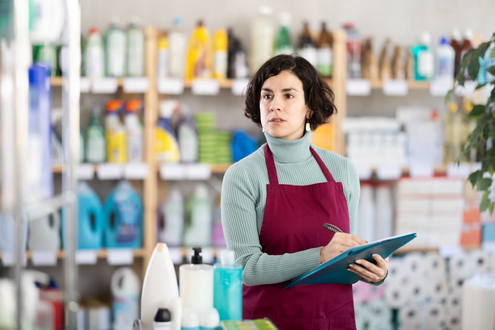 Adult woman seller conducting inventory in store