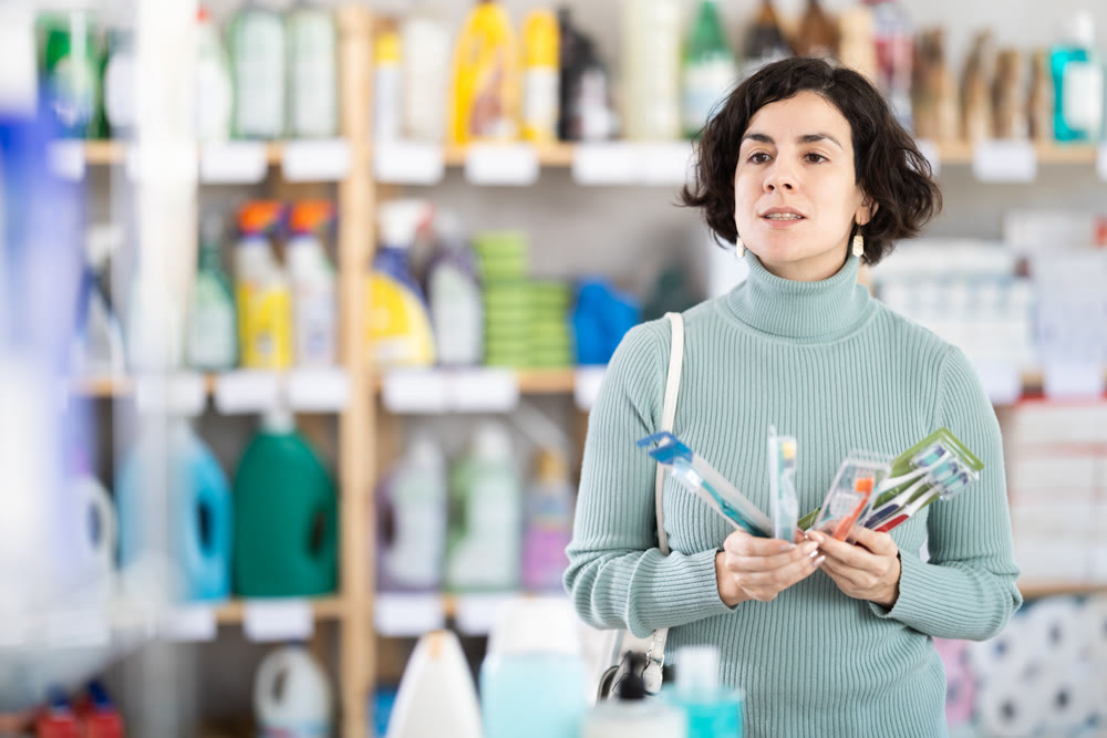 Middle-aged woman choosing toothbrush in retail store