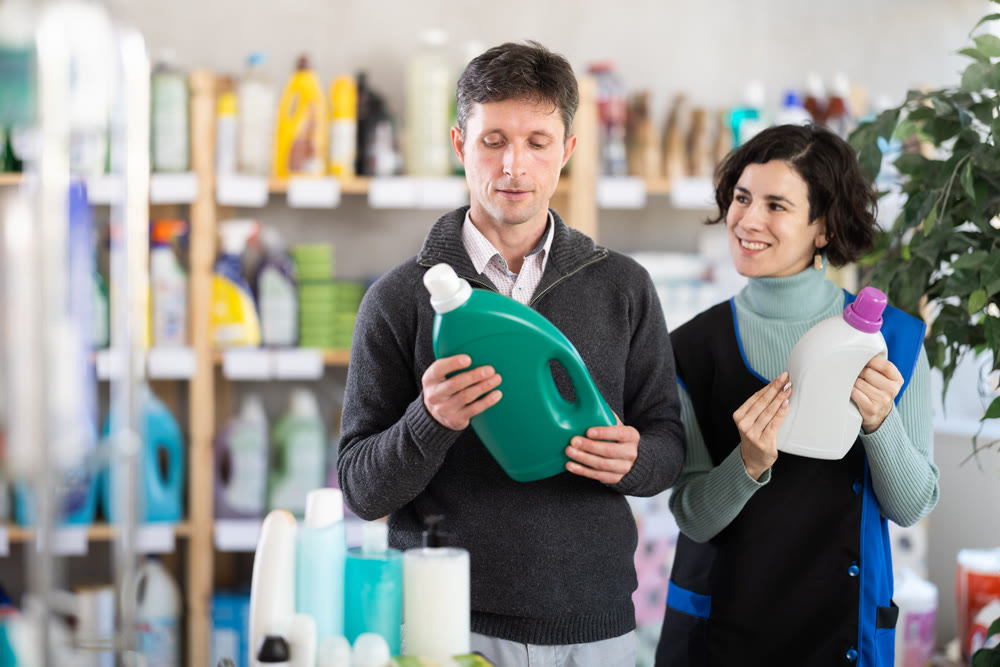 Female saleswoman offers man buy a detergent in supermarket