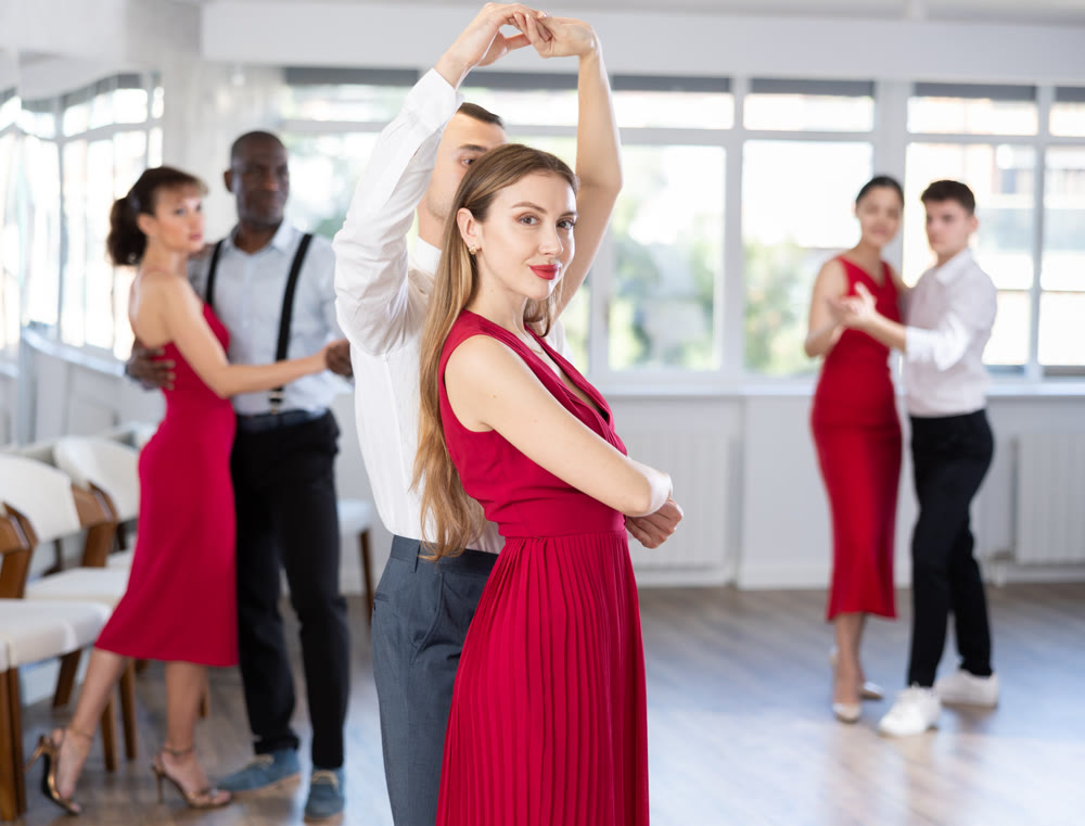 Young man and girl dancing waltz in couple during lesson at studio
