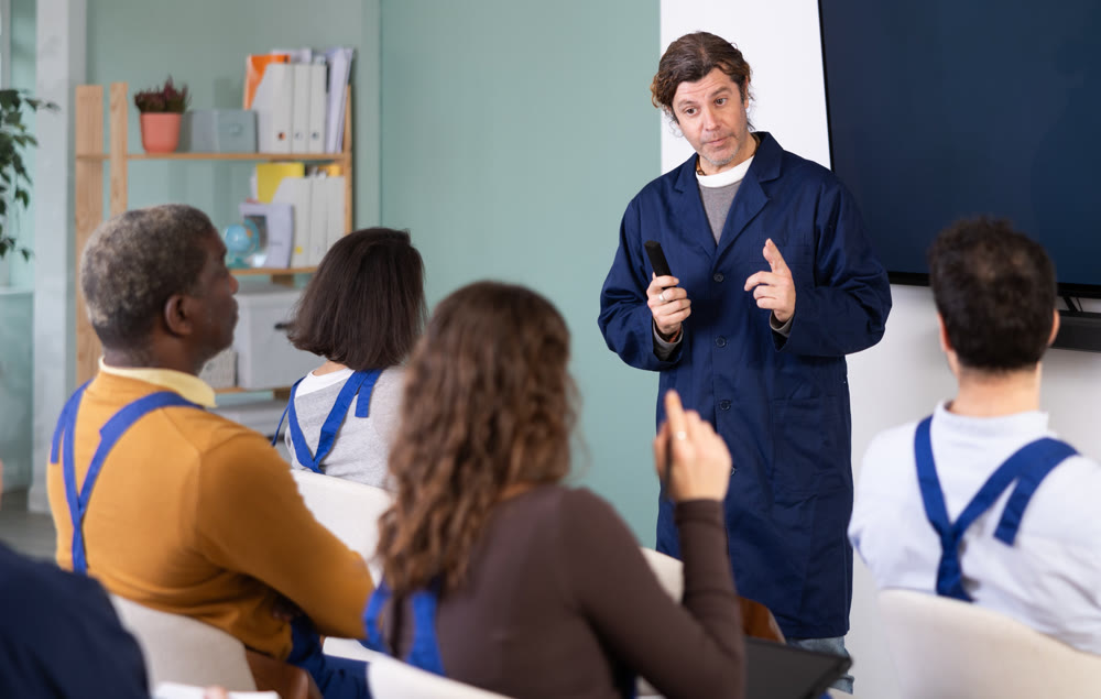 Middle aged man worker lecturer speaks to audience of listeners