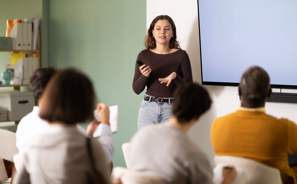 During lesson, girl teacher tells material and gives lecture