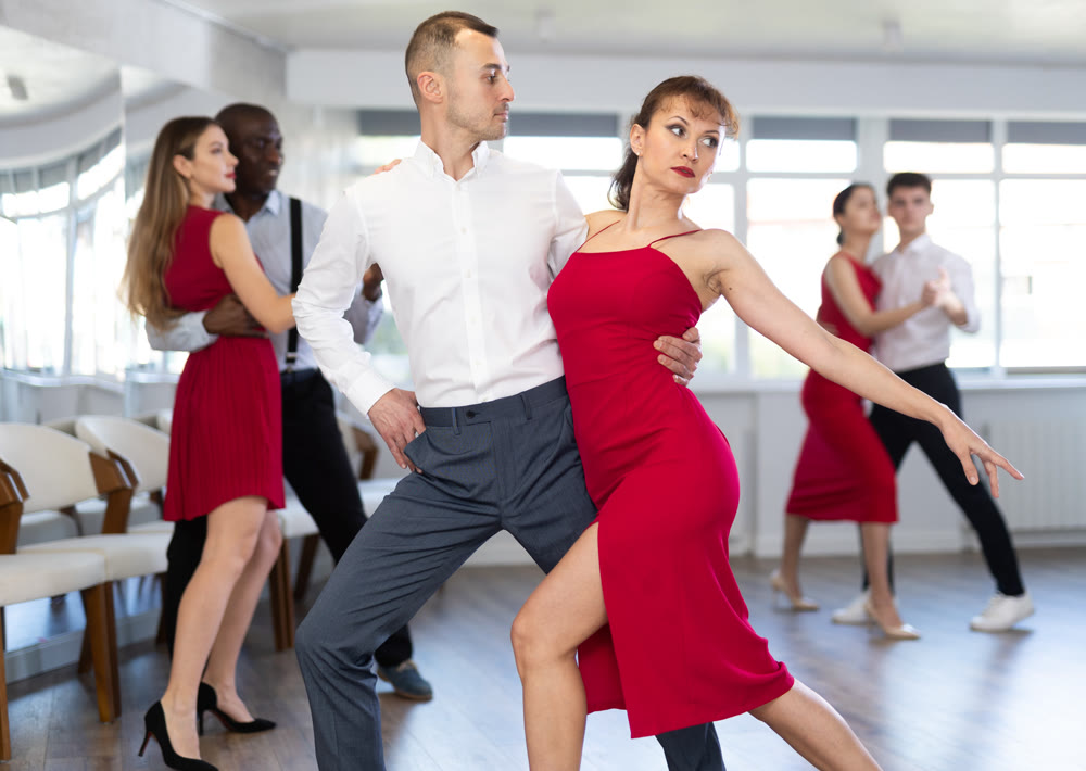 Young man and woman dancing tango in couple during lesson at studio