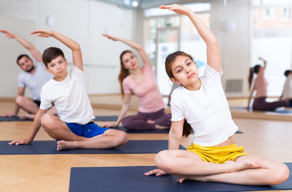 Kids and parents sitting in lotus pose and doing stretching moves