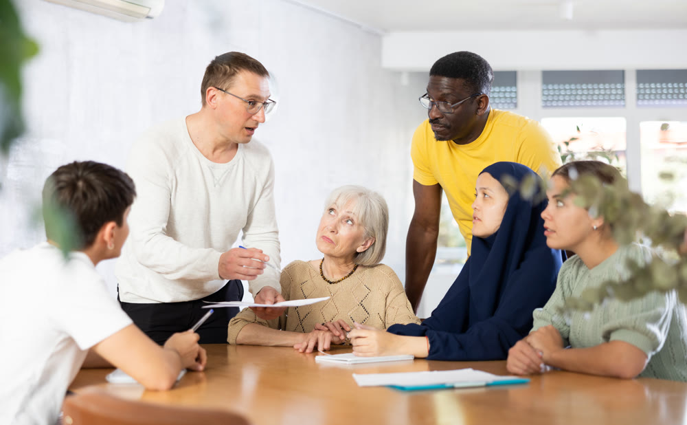 Group of multinational people making notes at table