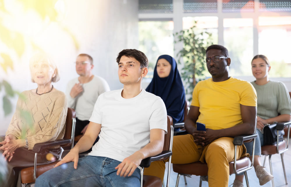 Guy teenager listens to lecture while sitting on chair