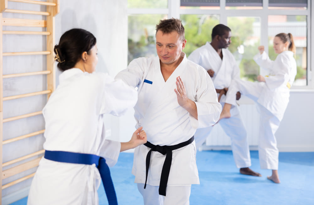 Multinational pupils train to perform defensive karate installations and attacking combat techniques