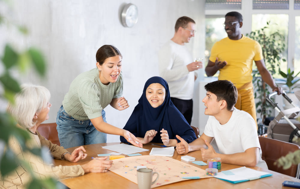 Cheerful young girl playing board game with friends