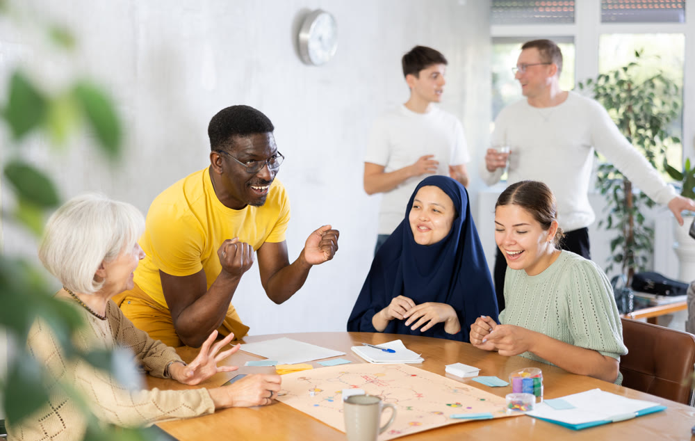 Group of multinational students of different years play board game with passion