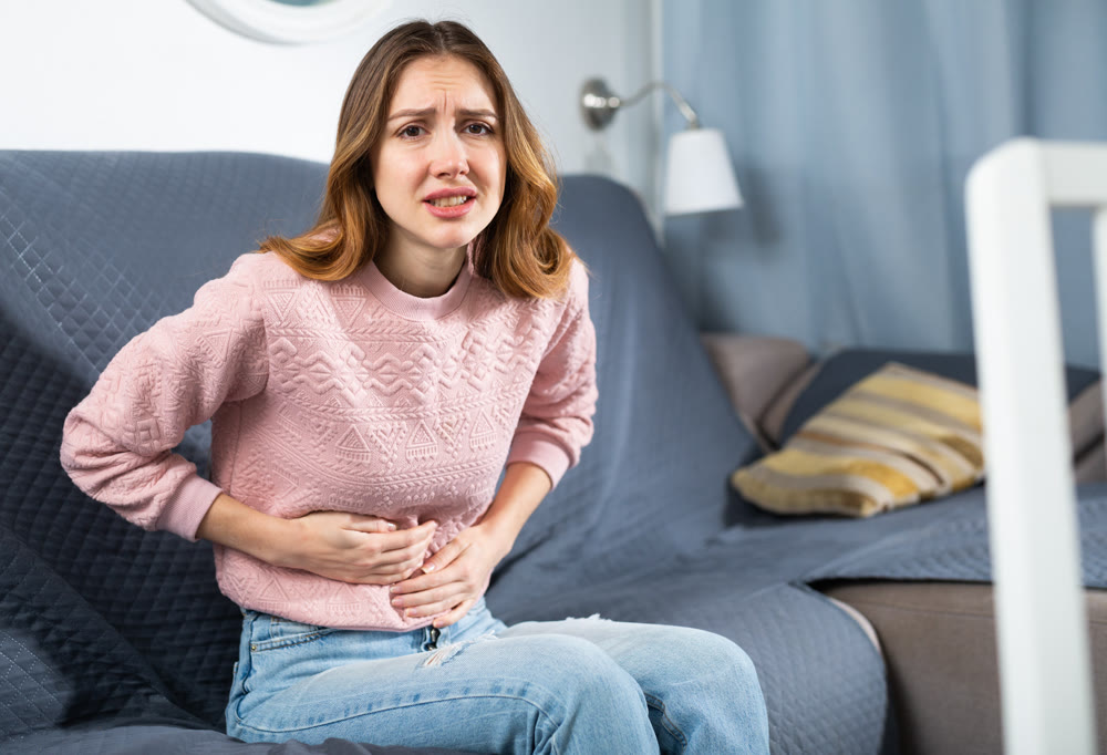 Young woman suffering from abdominal pain