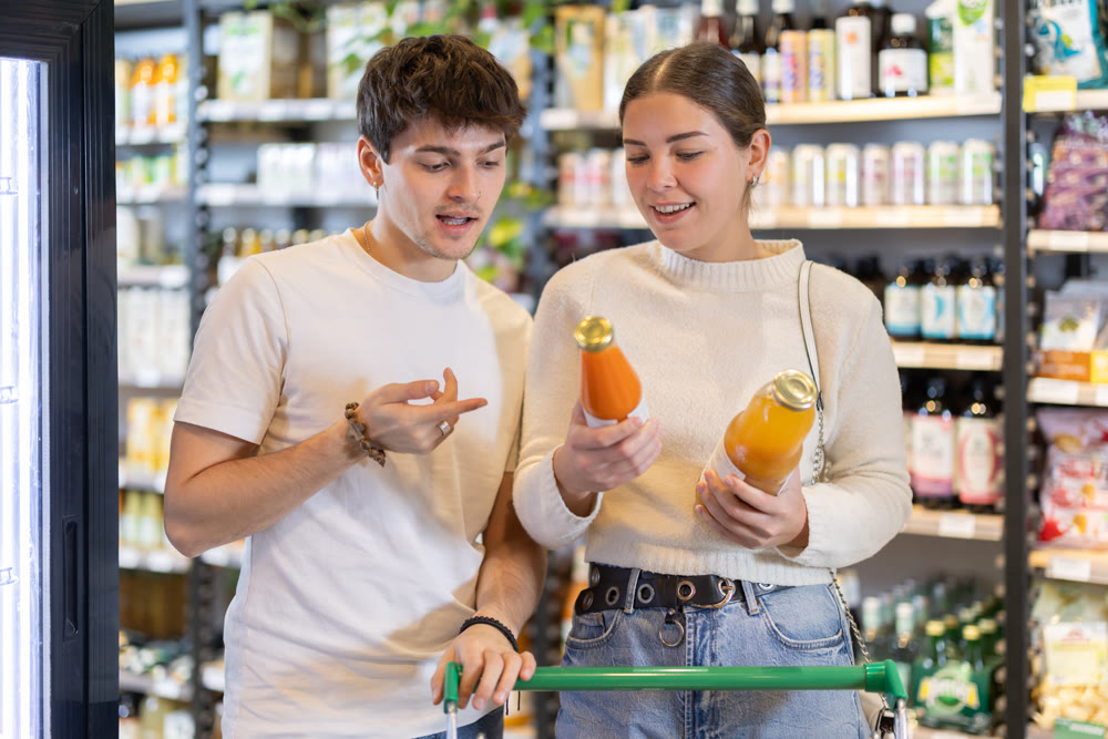 Couple man and woman choosing juices in grocery
