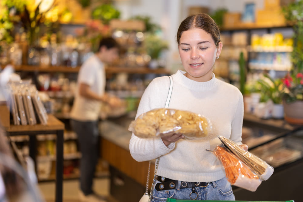 Store visitor, girl in sales area choosing pasta