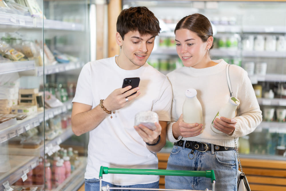 Woman and man scanning barcode of dairy packaging