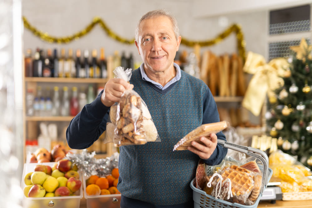 Elderly man choosing cookies at grocery store