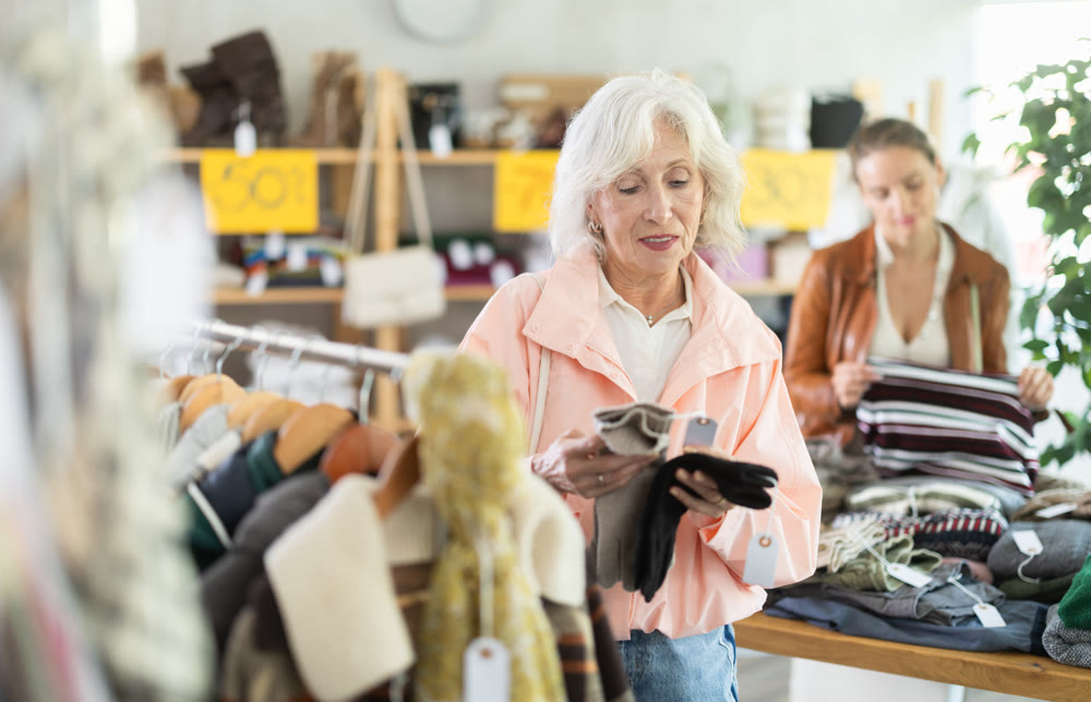 Elderly woman choosing gloves in clothing store