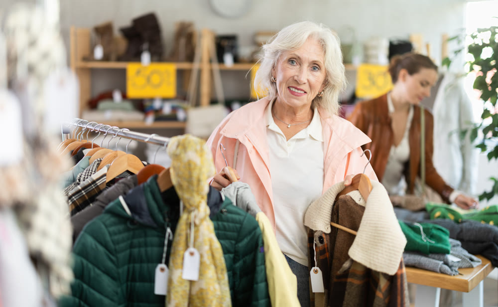 Senior woman customer examine and choose something autumn warm outwear in store