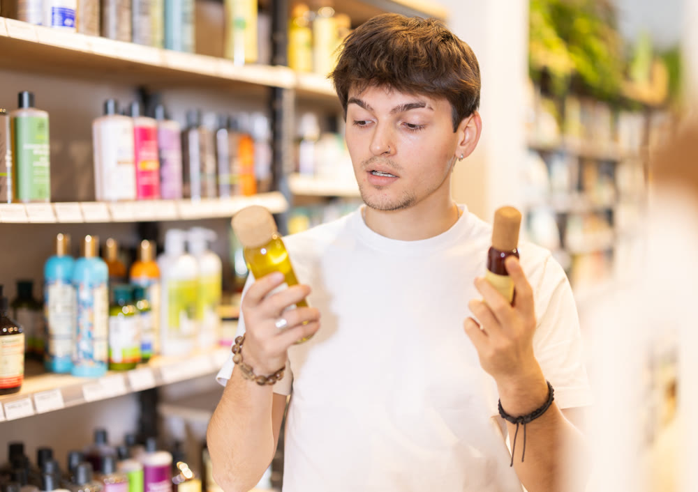 Guy chooses cosmetic oil for skin