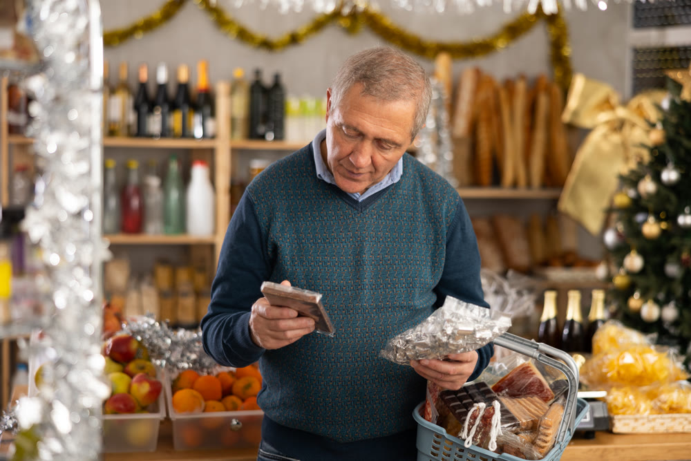 Portrait of mature man buying chocolate and chocolate candies for gift and celebrating Christmas