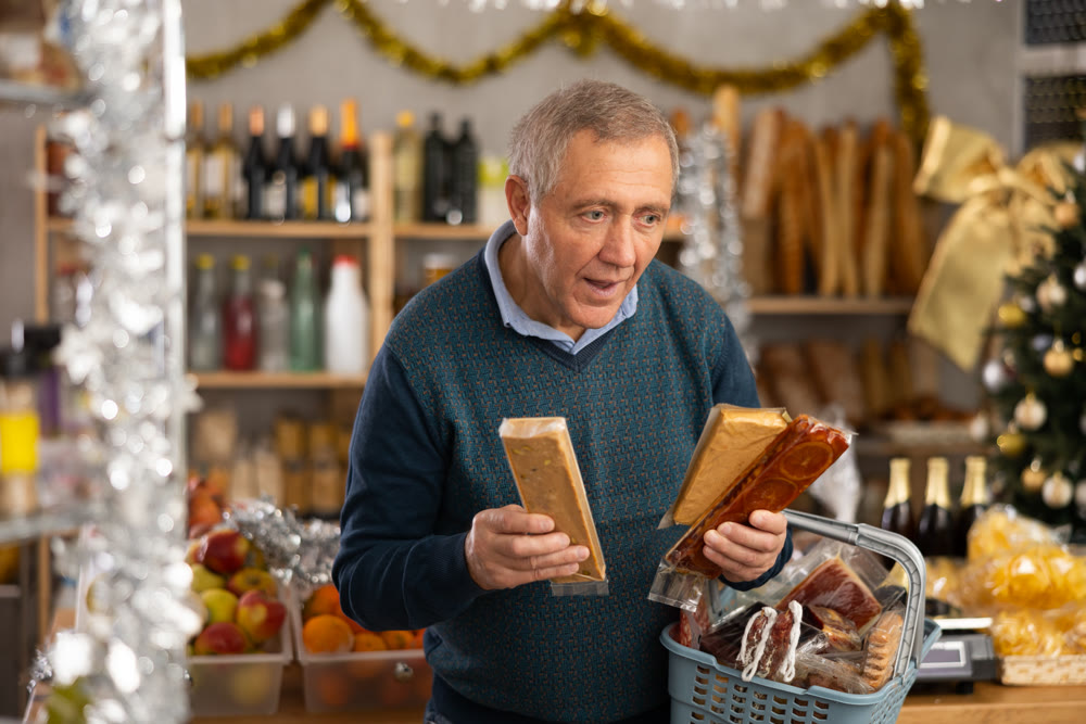 Elderly man choosing nougat in grocery store