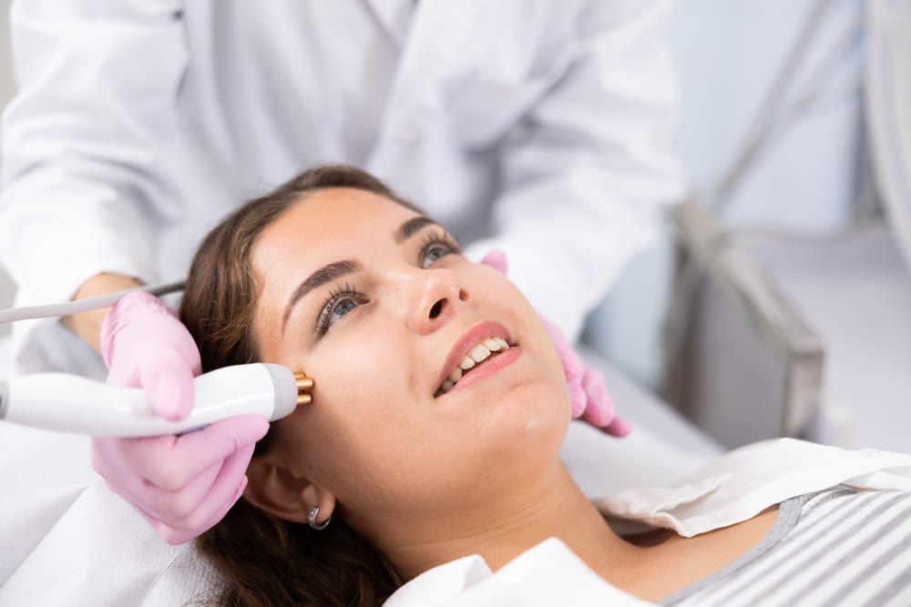 Young woman having face radiolifting procedure