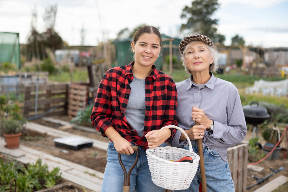 Portrait of positive young woman with an elderly mother after gardening