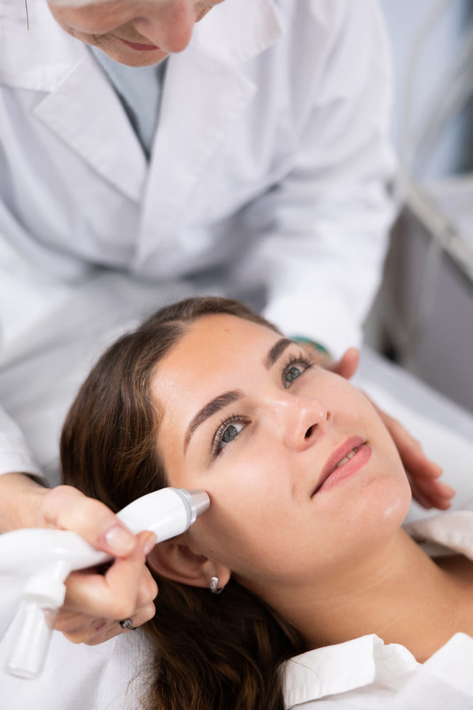 Young woman having face vacuum cleaning procedure