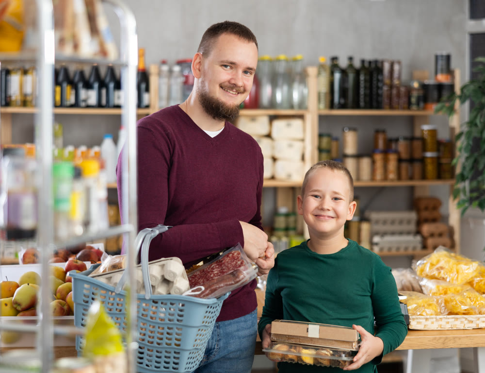 Dad and son are choosing products in supermarket