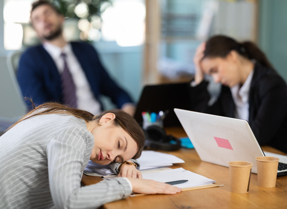Young girl napping at desk after long stressful workday