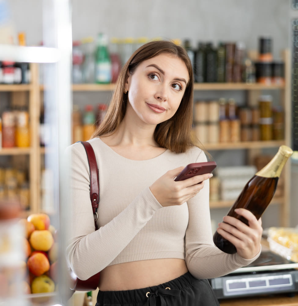 Young woman scanning qr code of beer