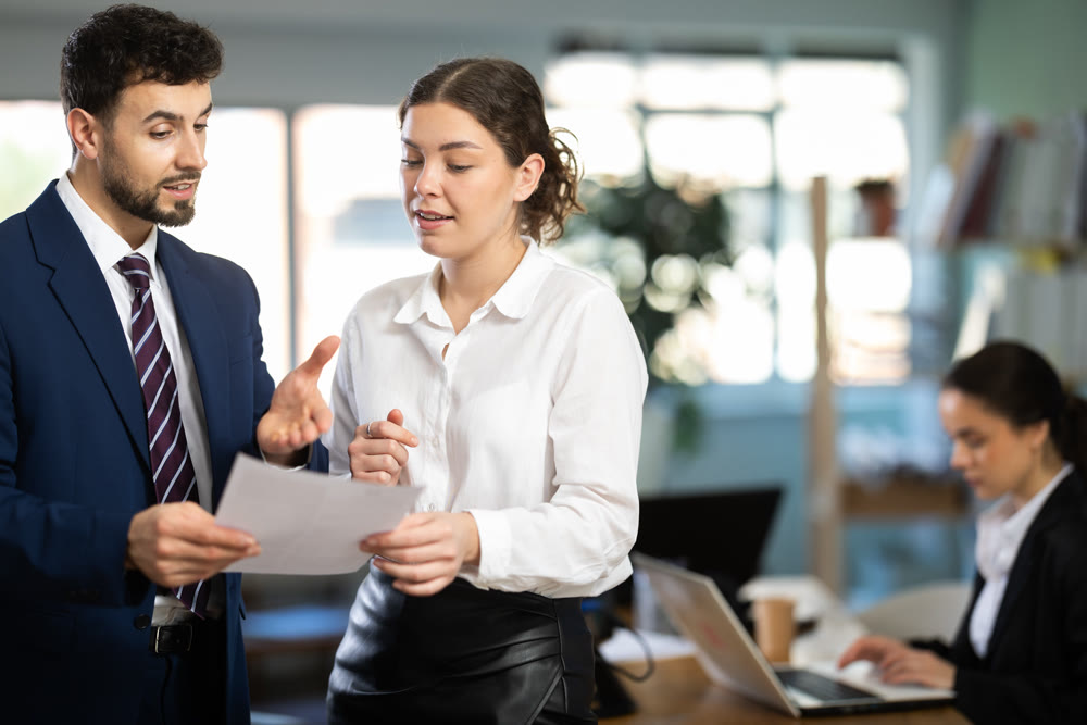 Male and female colleagues looking at document in office
