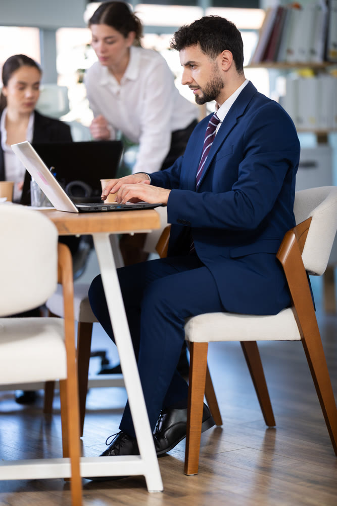 Focused young man working on laptop during busy corporate session