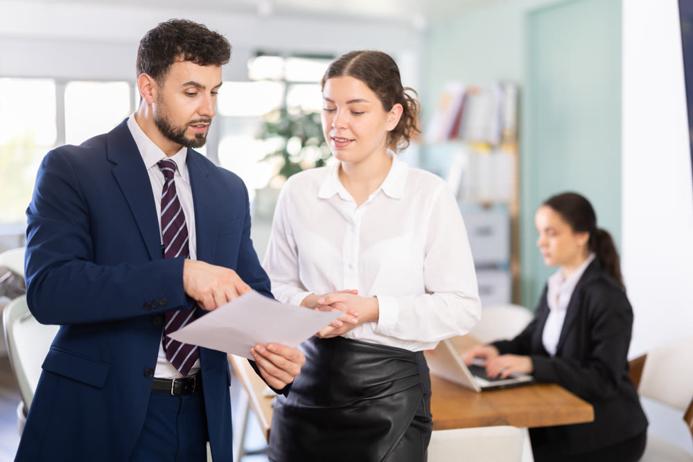 Male and female colleagues looking at document in office