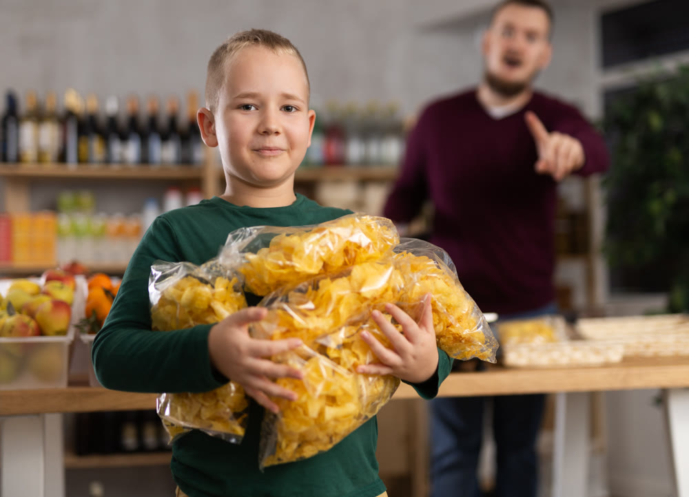 Boy chooses chips in grocery store