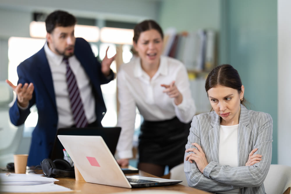 Angry office employees shout at a guilty employee who made mistakes in the project