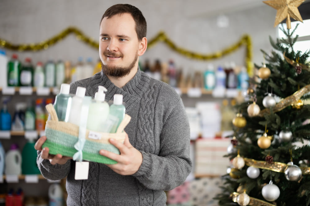 Interested nice bearded man choosing gifts for New Year in household department of supermarket
