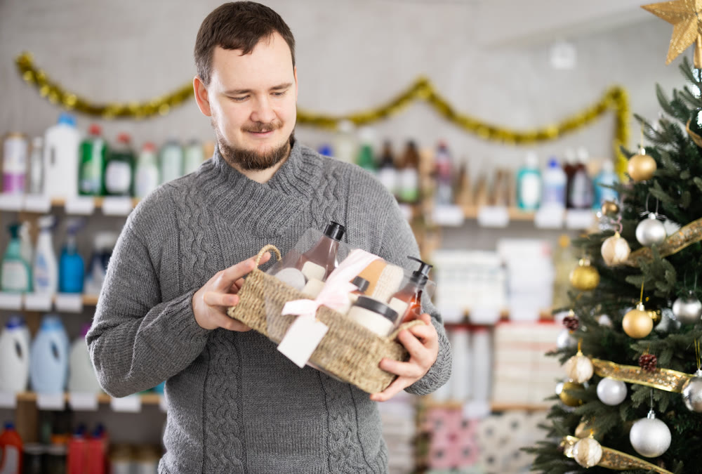 Middle-aged man choosing gift basket in supermarket during X-mas