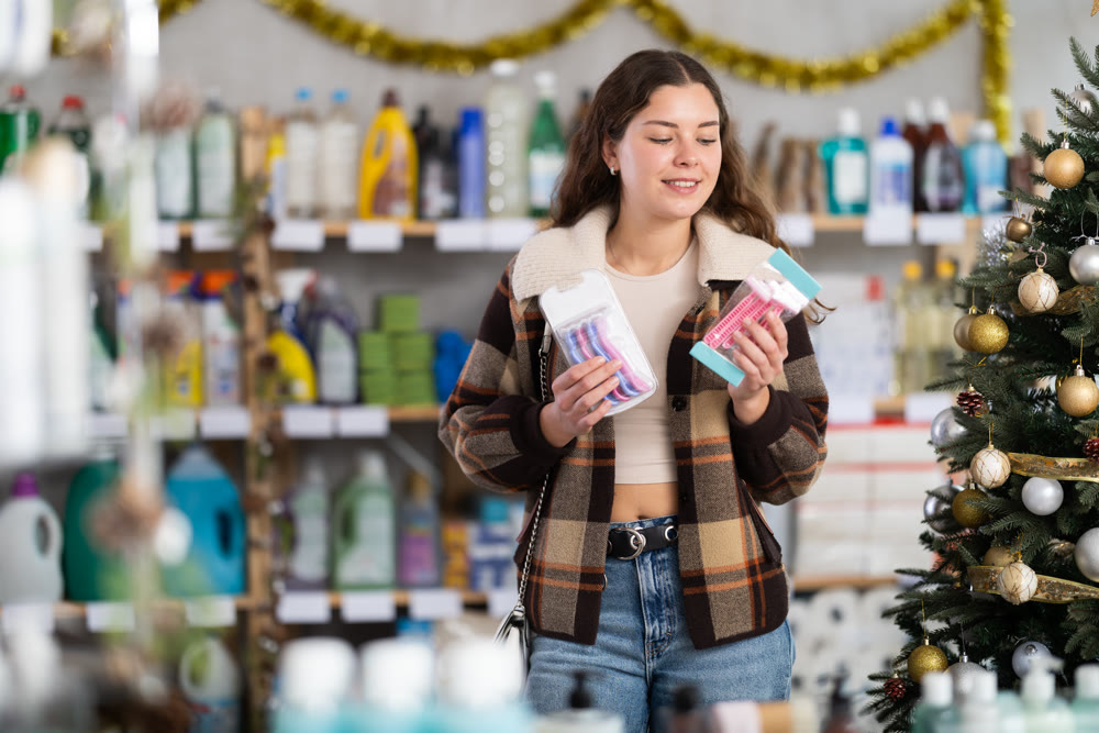 Young woman choosing razor in decorated store
