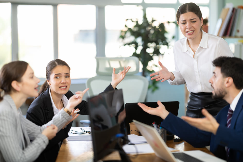 Group of men and women arguing loudly in office
