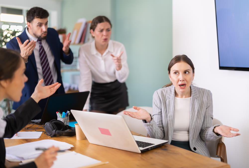 Angry office employees shout at a guilty employee who made mistakes in the project