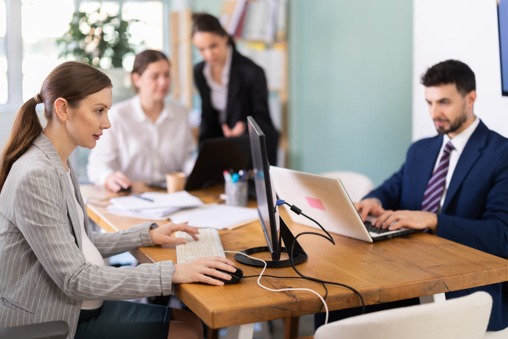 Focused young woman working on laptop during busy corporate session