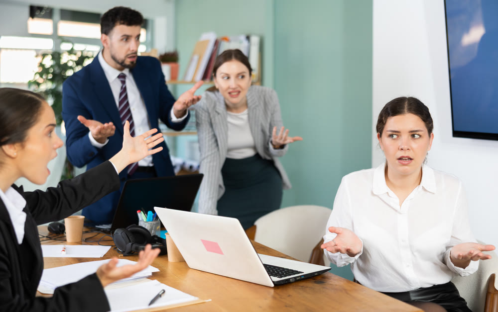 Angry office employees shout at a guilty employee who made mistakes in the project