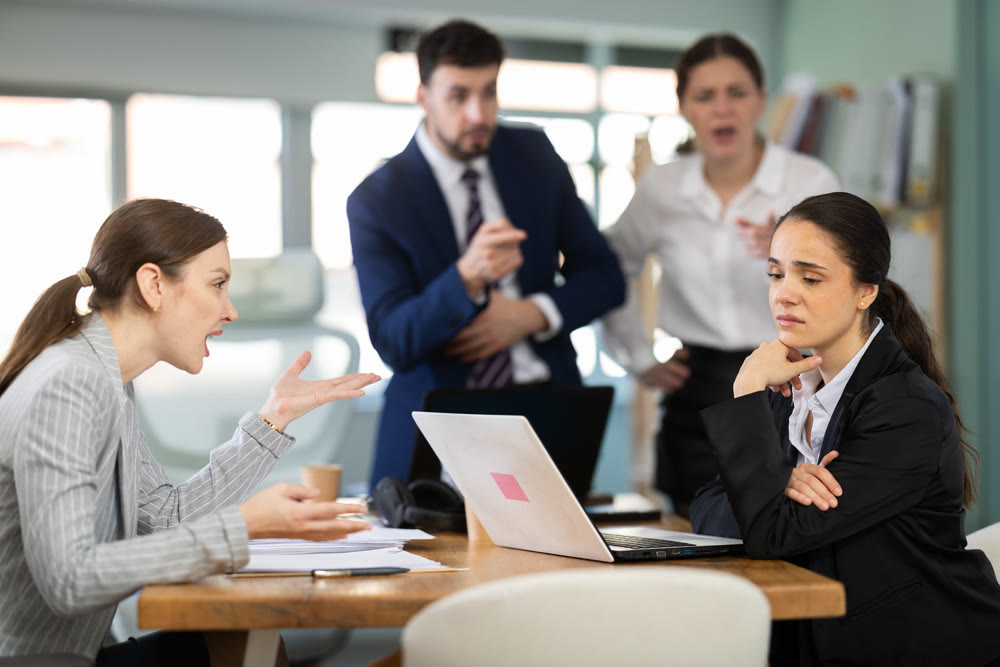 Angry office employees shout at a guilty employee who made mistakes in the project