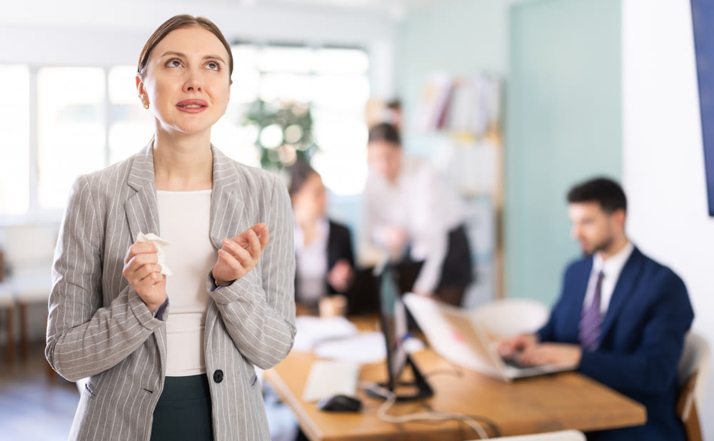 Upset woman stands in the middle of the office