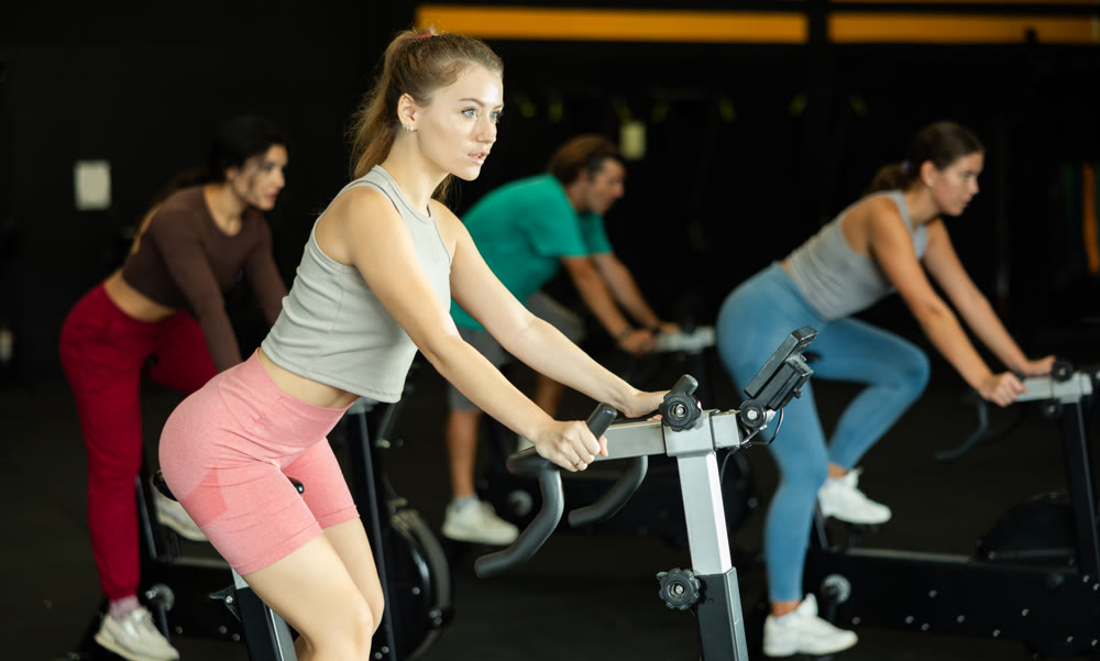 Athletic woman doing exercises on exercise bike