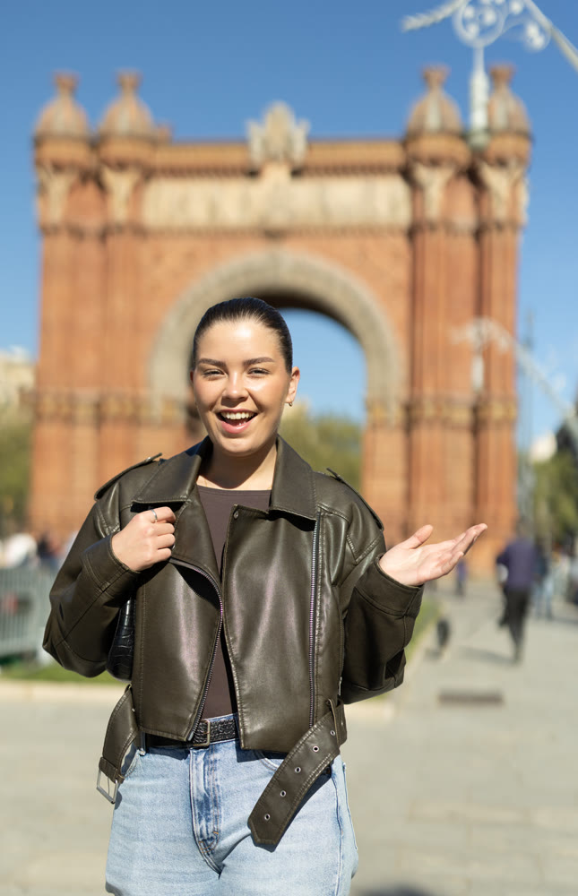 Portrait of girl in front of the Arc de Triomphe on sunny spring day. Barcelona, ​​Spain
