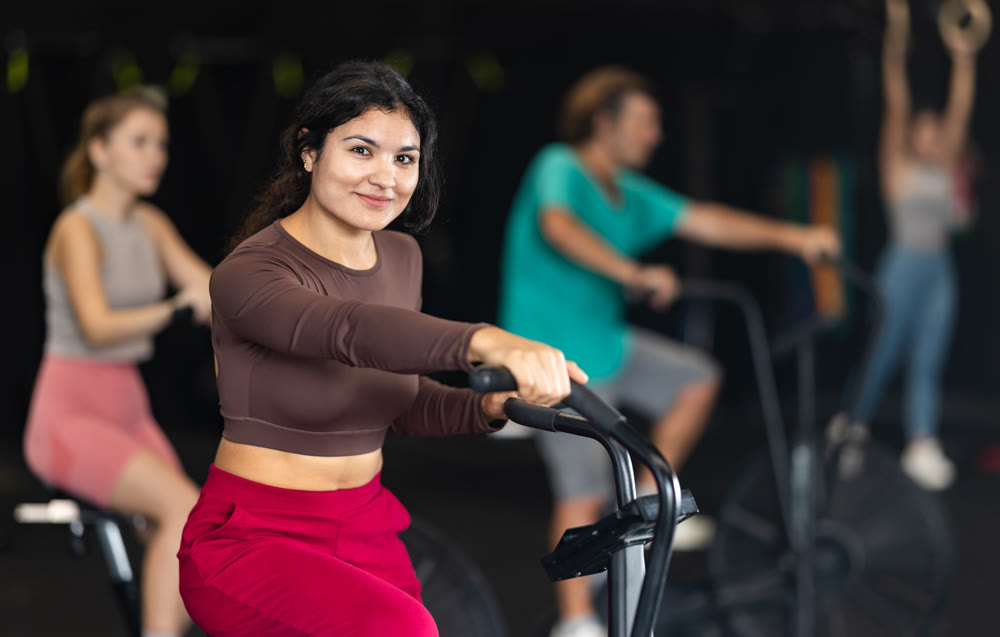 Latina woman doing exercises on air bike in Crossfit gym