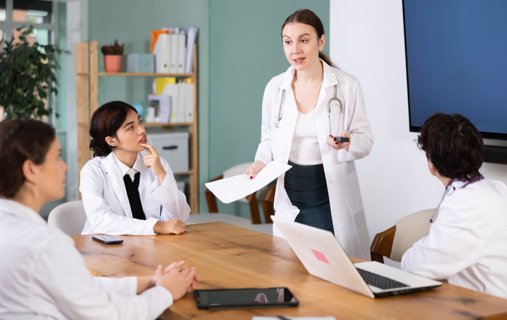 Young female doctor leading medical meeting in office
