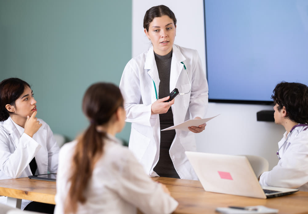 Young female doctor leading medical meeting in office