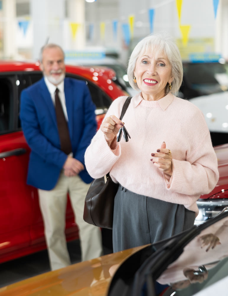 Elderly couple chooses new car together at car dealership