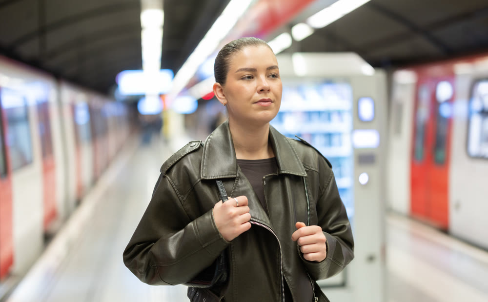 Pretty girl walks along the platform waiting for subway train